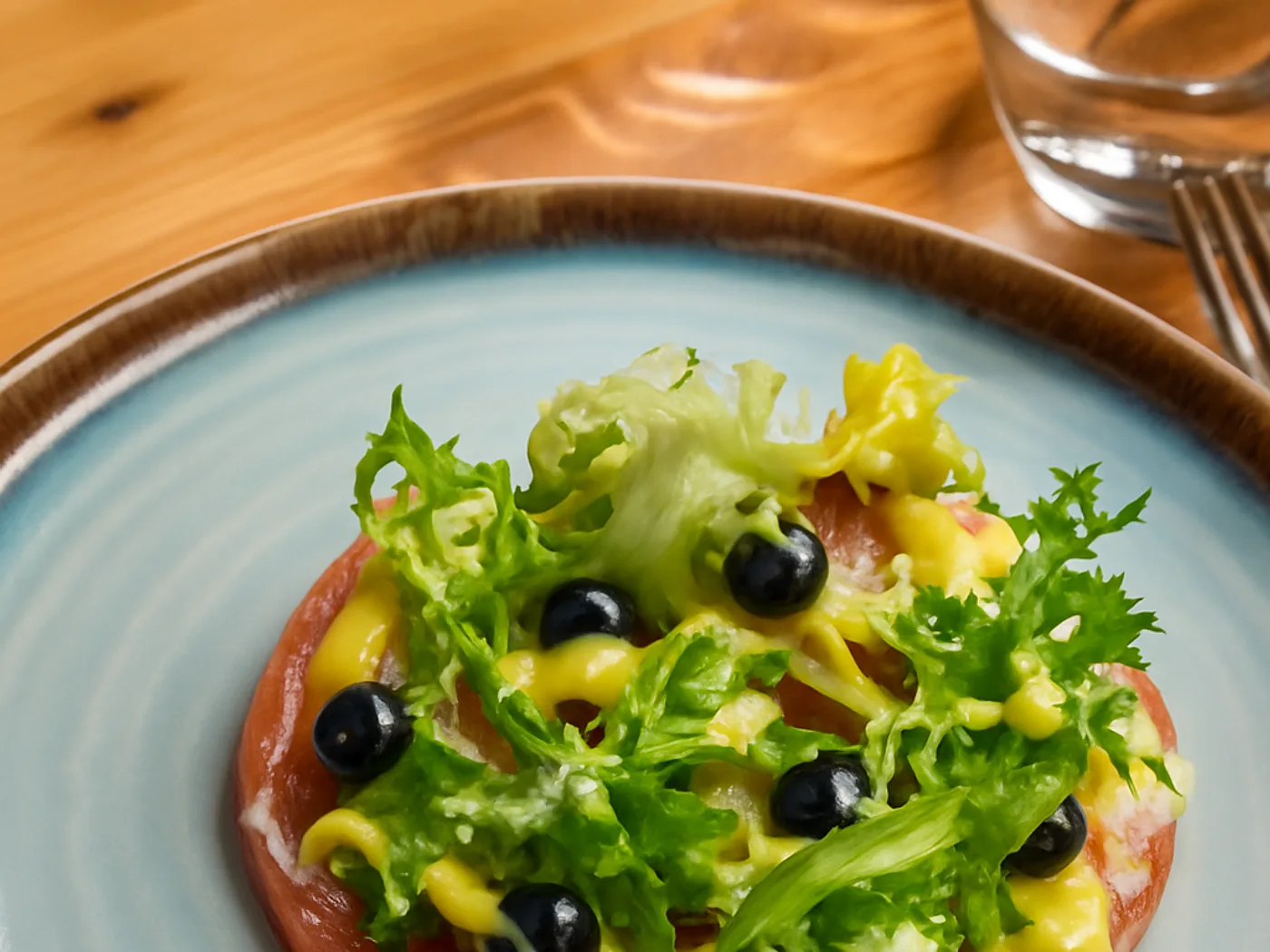 Focaccia con rucola, olive nere e crema di datterino giallo